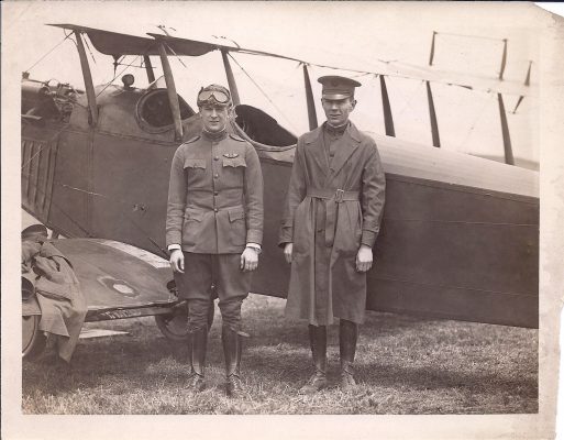 men in uniform standing next to an airplane