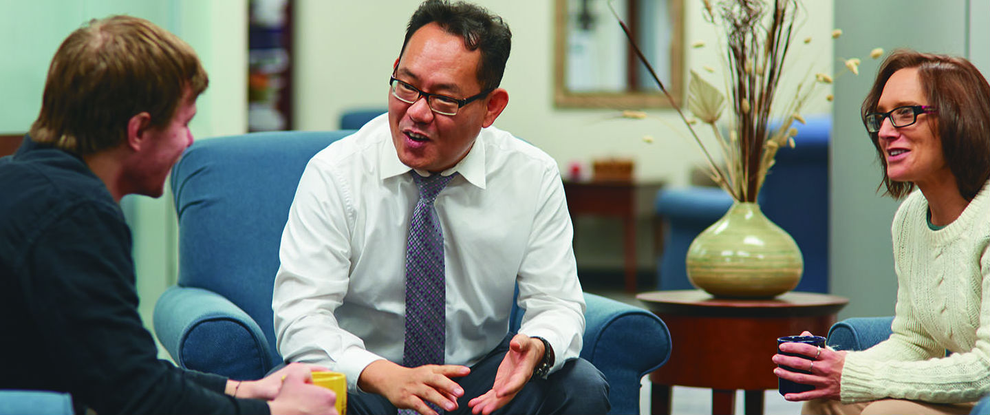 a person in a white shirt and tie talking to a person