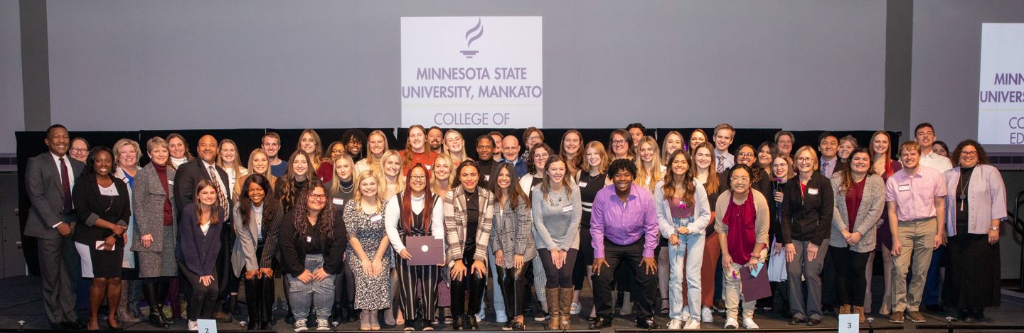 College of Education scholarship students on stage with faculty award