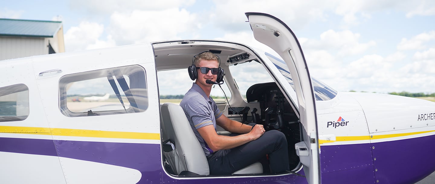 An aviation student sitting in a North Star Aviation plane wearing a headset at the Mankato Regional Airport 