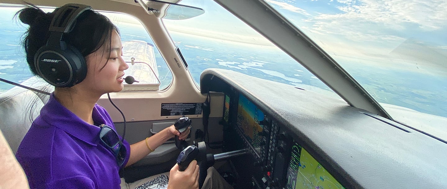 An aviation student flying a plane during her flying lesson