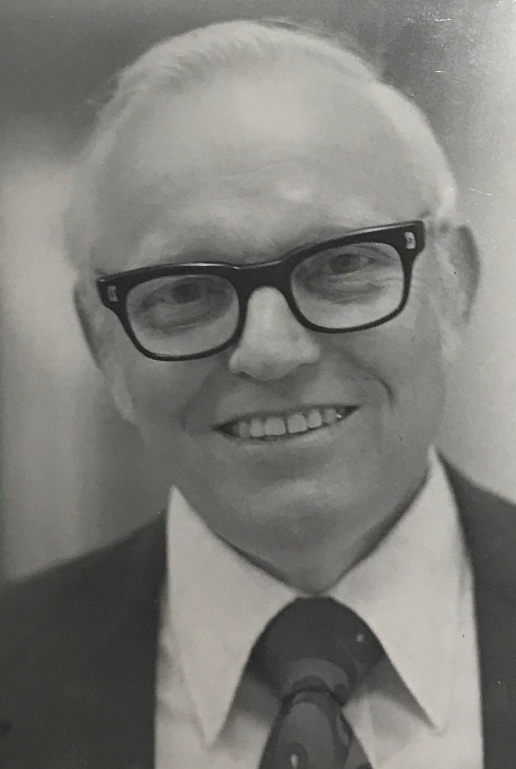 a person wearing glasses and a suit