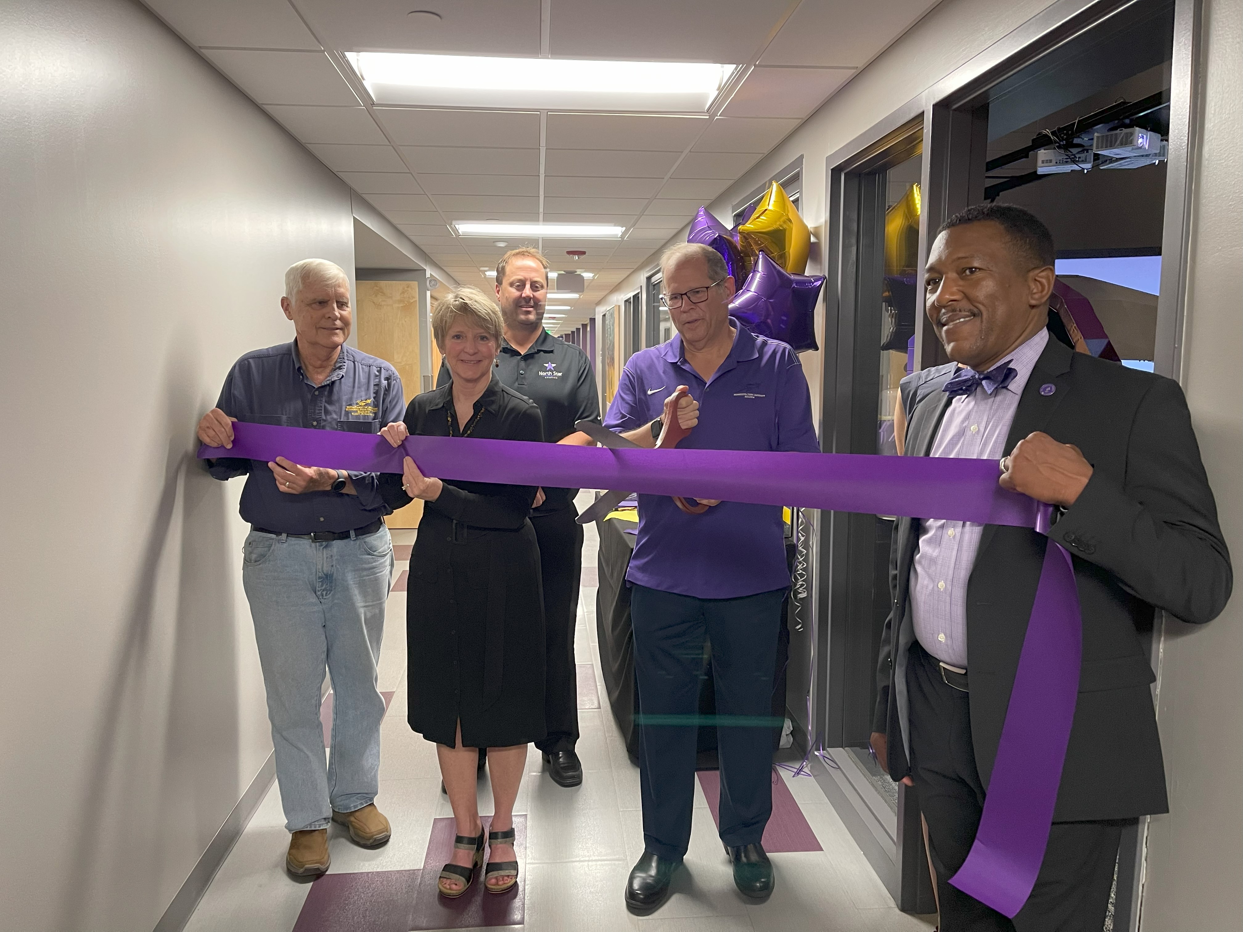 University members cutting the ceremonial ribbon for the Aviation SimLab
