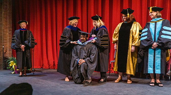 Student being hooded at the ceremony. 
